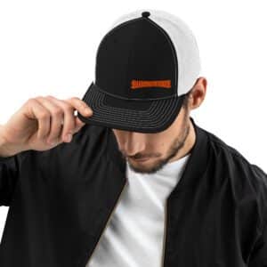 Black Trucker Cap with White Mesh and embroidered Barbeqquuuuueee logo on male model