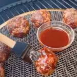 Saucing the bougie ball meatballs on the smoker